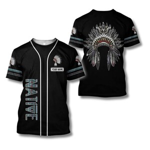 May include: Black baseball jersey with white trim and the word "NATIVE" in a patterned design. The jersey features a Native American headdress on the front and back. The text "YOUR NAME" is displayed on the front.