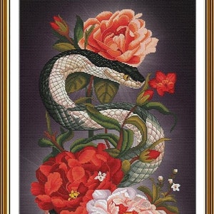 May include: A black and white snake wrapped around a bouquet of pink, white, and red flowers. The flowers are in bloom and have green leaves. The snake is coiled around the flowers and its head is facing the viewer.