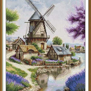 May include: Cross-stitch artwork depicting a European village scene with a windmill, houses, and a body of water. The artwork features a detailed landscape with trees, flowers, and a pathway, all rendered in various colors.