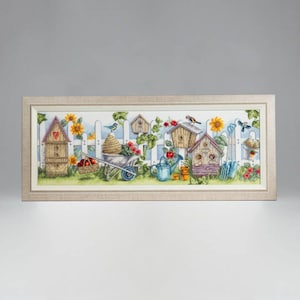 May include: Framed artwork depicting a garden scene with birdhouses, sunflowers, and a white picket fence. A wheelbarrow, watering can, and birds are also shown. The artwork is in a rectangular frame with a neutral colour.