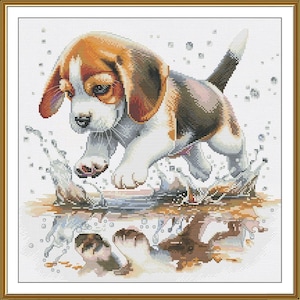 May include: Cross-stitch of a Beagle puppy jumping into water, creating a splash. The puppy has brown, white, and black markings. The water and its reflection are also visible, with a gold frame.