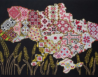 May include: A cross-stitch embroidery of the outline of Ukraine, filled with different traditional Ukrainian folk patterns in red, white, blue, yellow, and black. The outline of the country is surrounded by wheat stalks in gold.