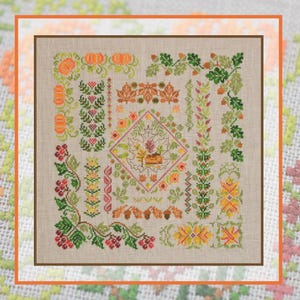 Könnte beinhalten: Ein Kreuzstich-Muster auf hellbeigem Stoff mit herbstlichem Motiv. Das Design zeigt orangefarbene Kürbisse, grüne Eichenblätter mit braunen Eicheln, rote Beeren und verschiedene florale Bordüren. In der Mitte befindet sich ein kleines Haus.