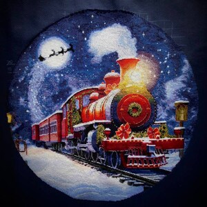 May include: A red and green Christmas train with a wreath on the front, pulling a string of boxcars. The train is decorated with greenery and red bows. The train is traveling through a snowy landscape under a starry night sky with a full moon and a flying sleigh.