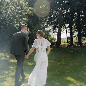 a modern bride wears sheer bridal cape made of light sheer chiffon