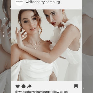 May include: Two women wearing white dresses. The woman in the front is wearing a white dress with a ruffled neckline and a gold necklace. The woman in the back is wearing a white dress with a ruffled neckline. The image is a social media post with the text 'whitecherry.hamburg' and '@whitecherry.hamburg: follow us on Instagram'.