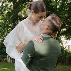 a modern bride wears sheer bridal cape made of light sheer chiffon
