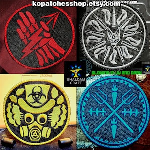 以下が含まれることがあります： 4つの円形刺繍パッチ。1つは、黒い背景に稲妻と矢印を持つ赤い手を示しています。もう1つは、弾丸に囲まれた白いキツネの顔を示しています。3つ目は黄色のガスマスクのデザインです。最後は交差した干し草フォークです。