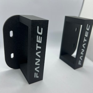 May include: Two black plastic wall mounts with the word "FANATEC" printed in white on the front.