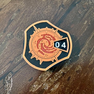 Puede incluir: Un contador circular negro y naranja con un diseño de remolino y una pantalla numérica que muestra "04".