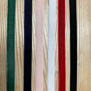 May include: Seven different colors of velvet ribbon, including green, navy blue, pink, white, red, and black.
