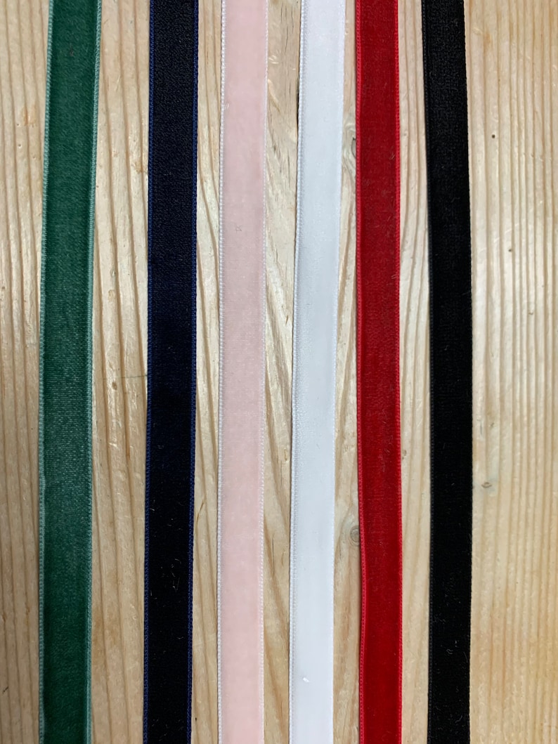 May include: Seven different colors of velvet ribbon, including green, navy blue, pink, white, red, and black.