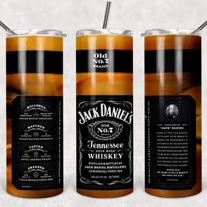 Puede incluir: Tres vasos de acero inoxidable con pajitas, con un diseño inspirado en el whisky Jack Daniel's. Cada vaso tiene una etiqueta negra con texto blanco y un fondo marrón y negro. Ideales para bebidas frías.