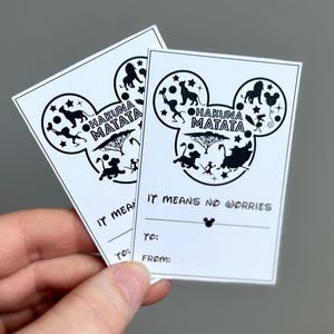 May include: Two black and white printable gift tags featuring a Mickey Mouse head silhouette. The silhouette is filled with characters from the film The Lion King. The text on the tags reads "Hakuna Matata" and "It means no worries".
