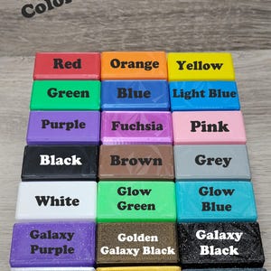 May include: A color chart featuring rectangular blocks in various colors, including red, orange, yellow, green, blue, light blue, purple, fuchsia, pink, black, brown, grey, white, glow green, glow blue, galaxy purple, golden galaxy black, galaxy black, silver, gold, and burnt titanium. The text "Color Chart" is at the top.