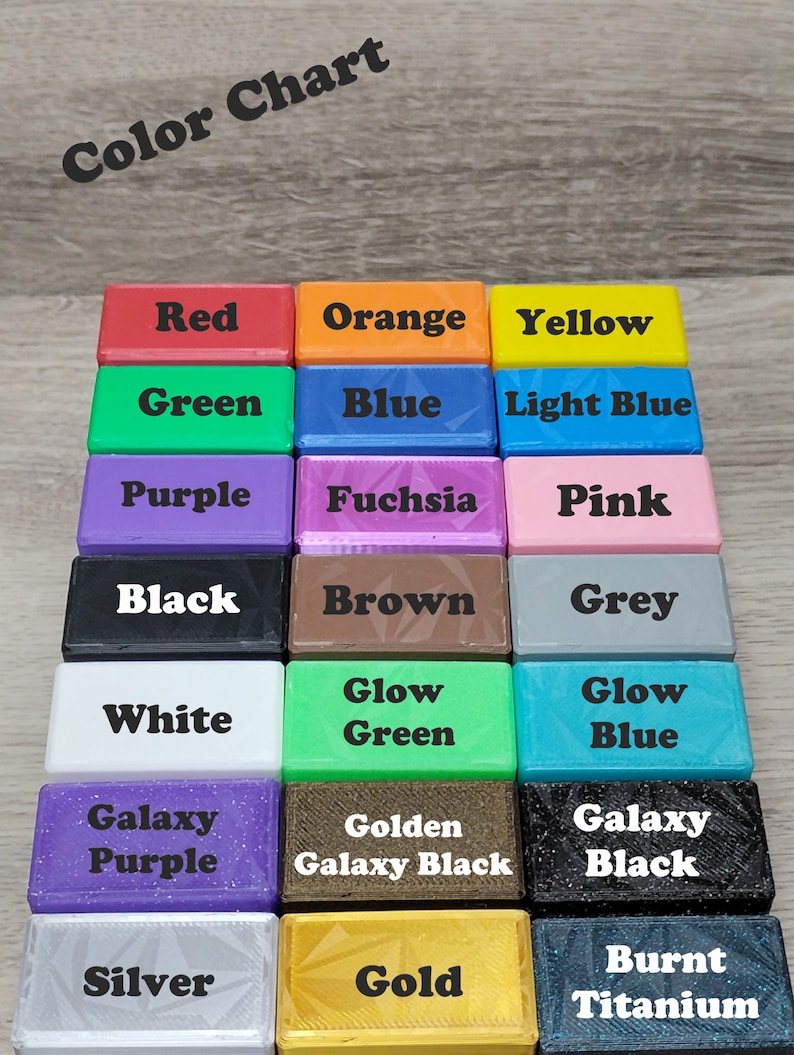 May include: A color chart featuring rectangular blocks in various colors, including red, orange, yellow, green, blue, light blue, purple, fuchsia, pink, black, brown, grey, white, glow green, glow blue, galaxy purple, golden galaxy black, galaxy black, silver, gold, and burnt titanium. The text "Color Chart" is at the top.