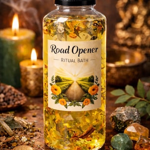 Puede incluir: Una botella transparente con tapa negra, llena de líquido amarillo y botánicos. La etiqueta dice "Road Opener - Ritual Bath" con una ilustración de carretera. El fondo incluye velas encendidas, monedas y cristales.