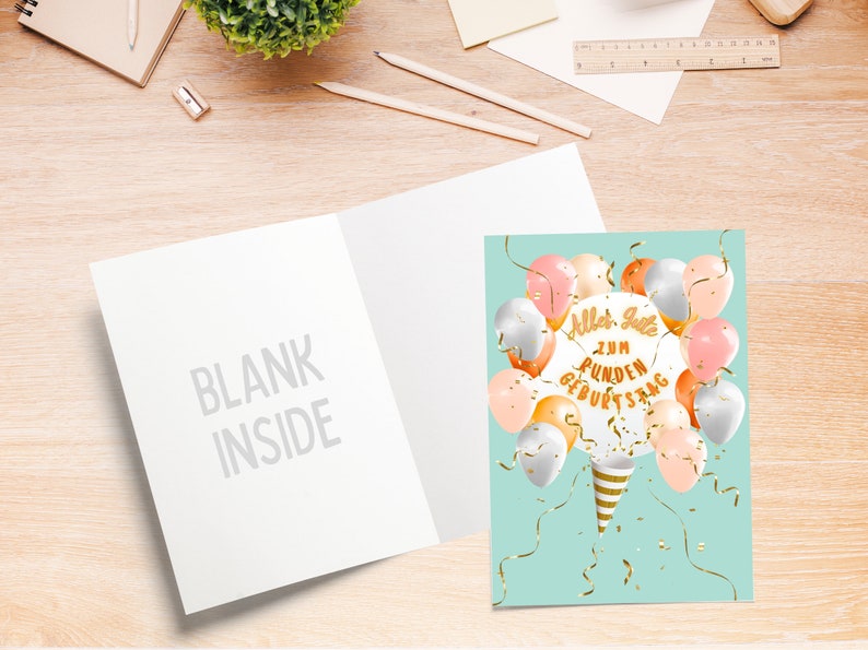 May include: A light blue card with a white inside. The front of the card has a design of balloons in shades of pink, peach, and silver with gold confetti and ribbons. The text on the card reads "Alles Gute zum runden Geburtstag".