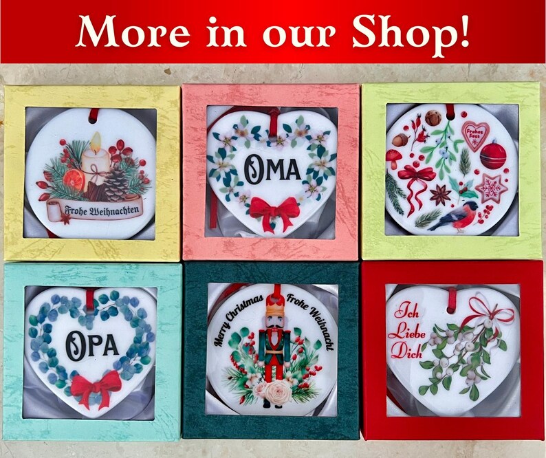 May include: Six heart-shaped ceramic ornaments in individual boxes. The ornaments feature various Christmas-themed designs, including a Christmas tree, a nutcracker, a heart with the word "OMA", a heart with the word "OPA", a heart with the words "Ich Liebe Dich", and a heart with the words "Frohe Weihnachten".