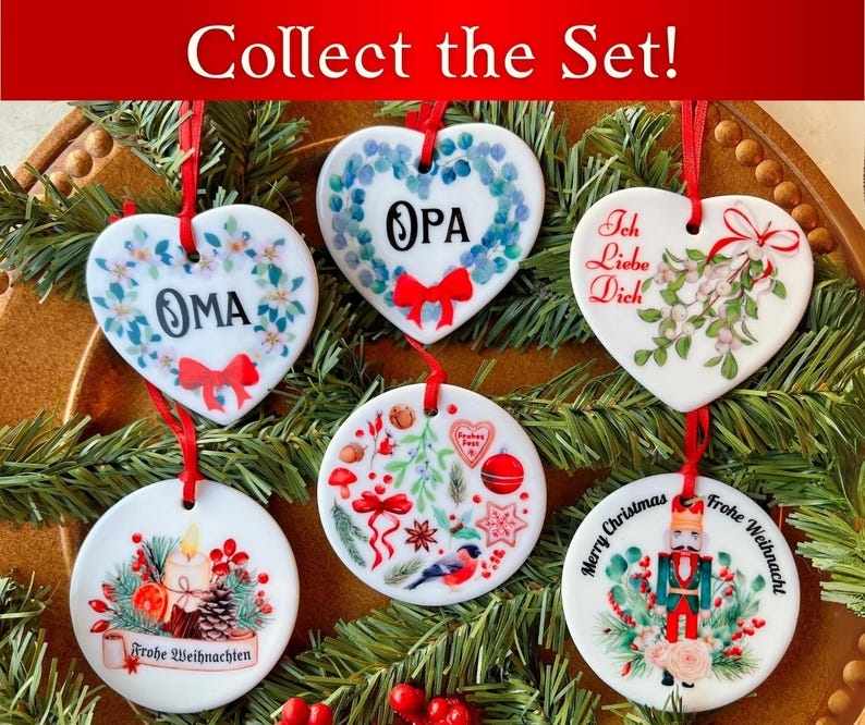 May include: Set of six white ceramic Christmas ornaments with various designs.  The ornaments are heart-shaped and round.  The designs include a wreath with the word "OPA", a wreath with the word "OMA", a design with the words "Ich Liebe Dich", a design with the words "Frohe Weihnachten", a design with the words "Merry Christmas", and a design with the words "Frohe Weihnachten" and a nutcracker.