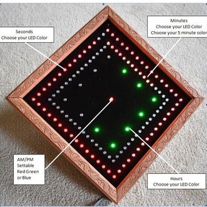 May include: A diamond-shaped LED clock with a brown wooden frame. The clock face is black, with red, green, and white LED lights indicating the time. Text on the image indicates options for LED colour customisation for seconds, minutes, hours, and AM/PM.