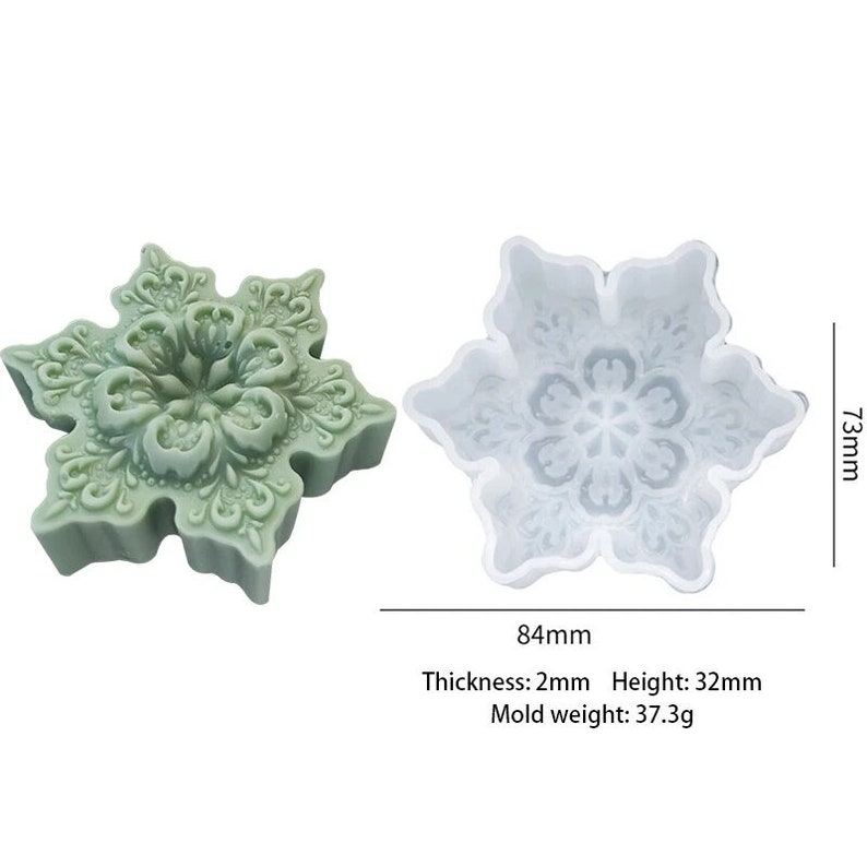 May include: A white silicone snowflake mold with a detailed design. The mold is 7.3 cm tall and 8.4 cm wide. The mold is 0.2 cm thick and weighs 37.3 grams.