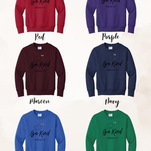 May include: A collection of six crewneck sweatshirts in various colors: red, purple, maroon, navy, royal blue, and kelly green. Each sweatshirt features the phrase "Be Kind" with a heart and bee design, along with the reference "Ephesians 4:32" in black script.
