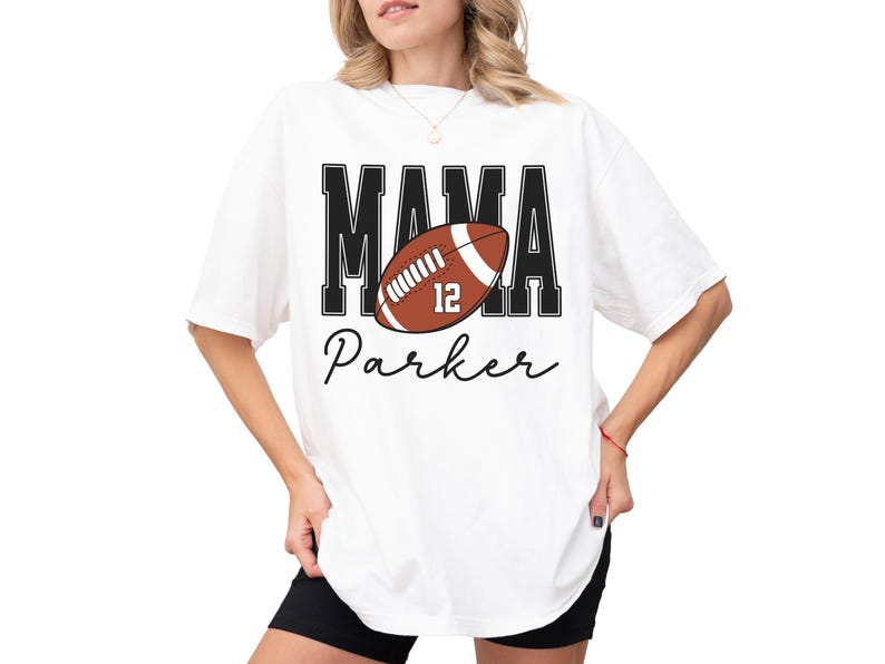 Custom Football Mama Shirt. The tshirt says football mama in varsity font and is personalized with the players number on a large football and name below it. Comfort Colors tee, crewneck, short sleeves football mom t shirt