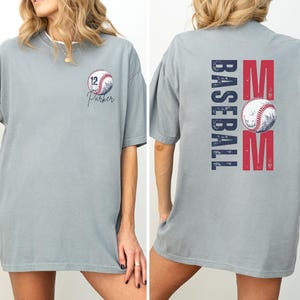 Custom baseball Mom Shirt. The baseball TShirt says baseball mom on the back in navy and red. The front is personalized with a baseball and the player name and number. Comfort colors tee, crewneck, short sleeves
