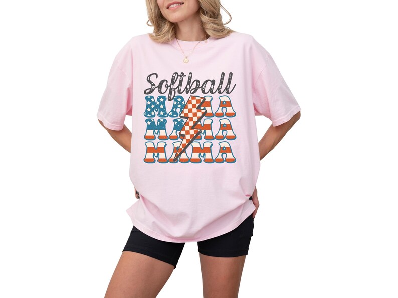 Retro patriotic softball mama shirt for 4th of July and Memorial day. The t shirt says, softball in black distressed script and the word mama repeated 3 times in a red white and blue USA flag font. A checkered lightning bolt down the middle