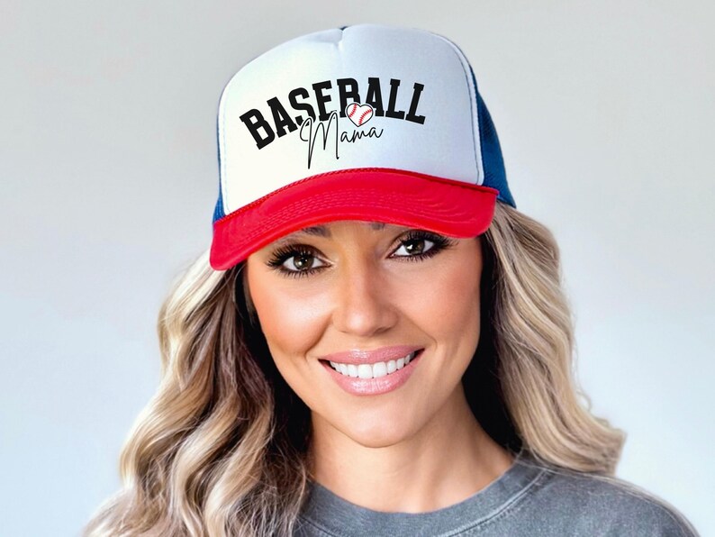 May include: A white, red, and blue baseball cap with a mesh back. The front of the cap has the text "Baseball Mama" in black with a red heart and a baseball graphic.