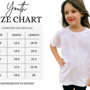 May include: A white t-shirt on a young person, with a size chart labeled "Youth Size Chart." The chart lists sizes XS to XL, with width and length measurements in inches. The shirt is made of Comfort Colors 9018 material.