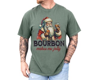 Könnte beinhalten: Ein grünes T-Shirt mit einer Vintage-Illustration von Weihnachtsmann, der ein Glas Bourbon hält. Der Text "Bourbon makes me jolly" ist unter dem Bild gedruckt.