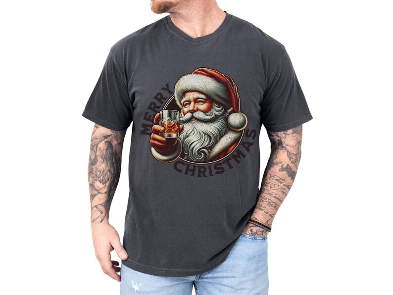 Christmas drinking shirt graphic tee. The t shirt has a distressed, vintage Santa that is holding a glass of whiskey or bourbon on the rocks. The tshirt says Merry Christmas. Comfort Colors tee, short sleeves, crewneck