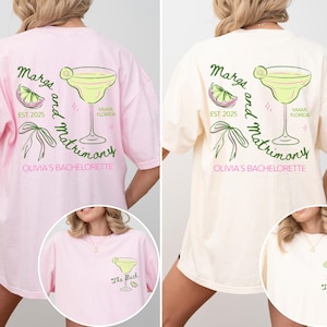 May include: Two pink and cream colored t-shirts with a margarita and the text "Margs and Matrimony" on the back. The front of the shirts have the text "The Bach" and "The Bride" on them.