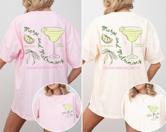 May include: Two pink and cream colored t-shirts with a margarita and the text "Margs and Matrimony" on the back. The front of the shirts have the text "The Bach" and "The Bride" on them.