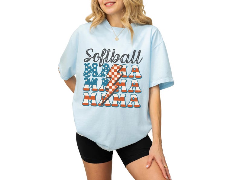 Retro patriotic softball mama shirt for 4th of July and Memorial day. The t shirt says, softball in black distressed script and the word mama repeated 3 times in a red white and blue USA flag font. A checkered lightning bolt down the middle