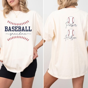 May include: A white t-shirt with the text "Baseball grandma" and a baseball graphic on the front. The back of the shirt has two baseball graphics with the names "Parker" and "Hudson" written underneath.