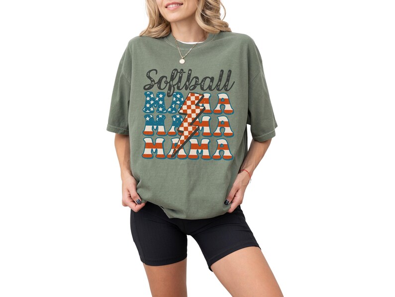 Retro patriotic softball mama shirt for 4th of July and Memorial day. The t shirt says, softball in black distressed script and the word mama repeated 3 times in a red white and blue USA flag font. A checkered lightning bolt down the middle