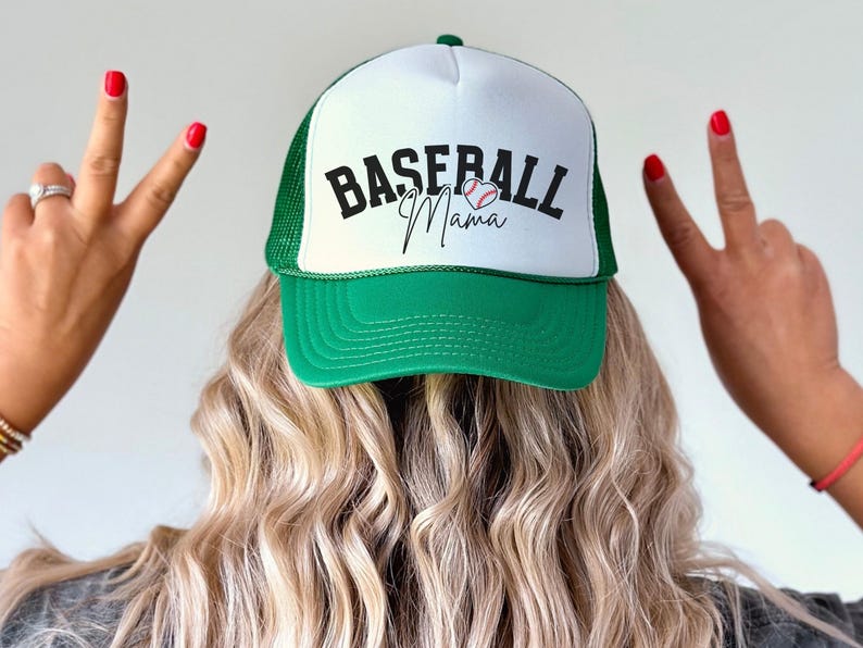 May include: A green and white baseball cap with a mesh back. The front of the cap has the text "Baseball Mama" with a baseball and heart graphic.