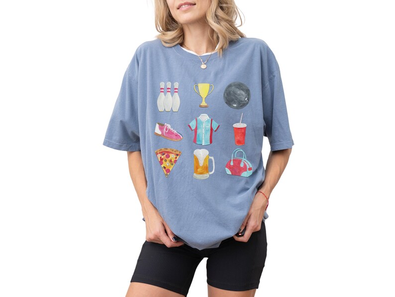 Retro bowling shirt for women. The tshirt has watercolor graphics and features bowling pins, trophy, bowling ball, shoes, shirt, soda, pizza, beer and a bowling bag. Short sleeves, crewneck, comfort colors, ivory