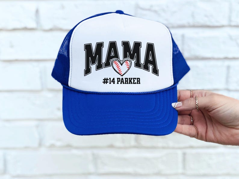 Custom baseball mom hat. the baseball hat says mama and has a baseball shaped heart in the center. the baseball mom trucker hat is personalized with the player name and number. adjustable, mesh back, baseball trucker hat