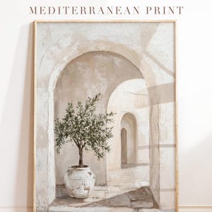 Könnte beinhalten: Ein gerahmter Druck mit dem Titel "Mediterranean Print" zeigt einen weißwandigen Bogengang mit einem Topf-Olivenbaum. Das Kunstwerk verwendet weiche, neutrale Töne und schafft eine beruhigende Ästhetik.