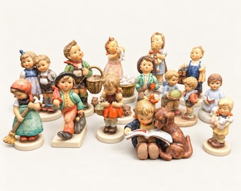 May include: A collection of fifteen hand-painted ceramic figurines depicting children in various activities, including reading with a dog, carrying baskets, holding books, and sweeping, all mounted on individual circular or rectangular bases.