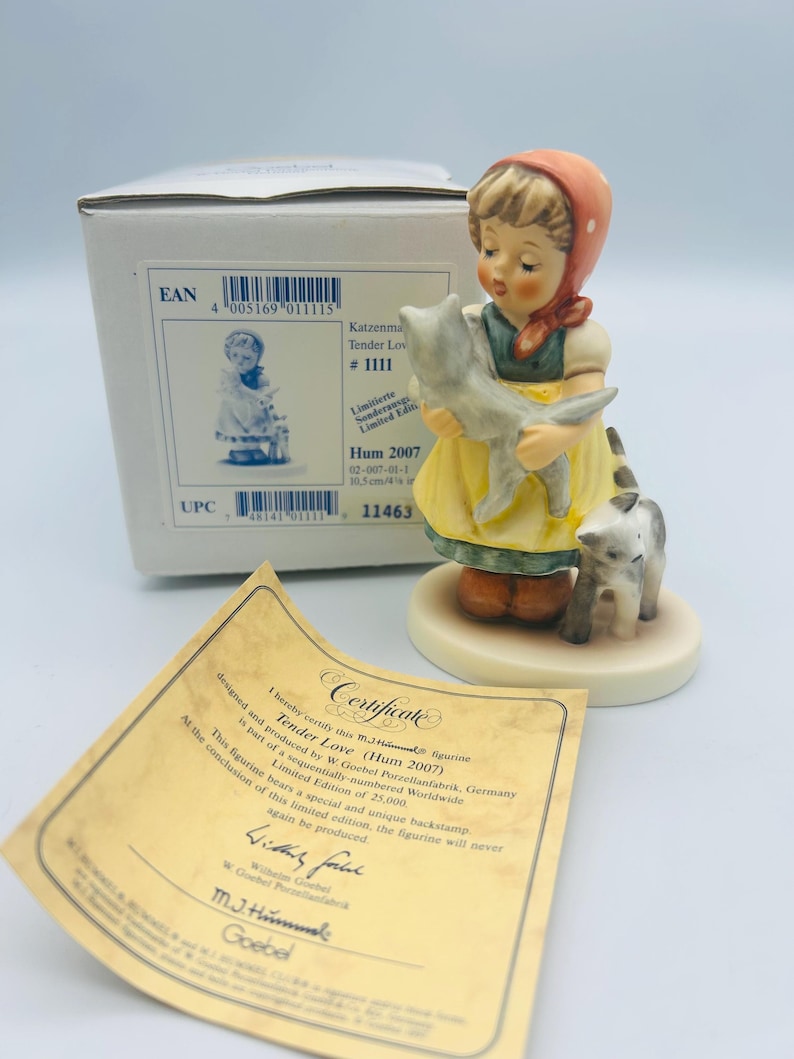 May include: A porcelain figurine titled "Tender Love" depicts a young girl in a yellow dress holding a gray cat, with another cat at her feet. The figurine is part of a limited edition, with a certificate and box visible.