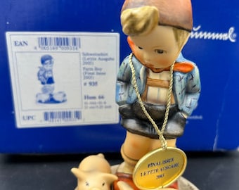 May include: A Hummel figurine of a young boy in a blue jacket and brown hat, standing with two small pigs. The figurine has a gold-coloured tag that reads "FINAL ISSUE LETZTE AUSGABE 2005". The base is approximately 6.35 cm in diameter.