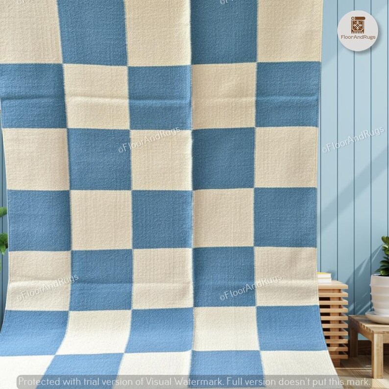May include: A rectangular rug featuring a repeating checkered pattern of alternating light blue and off-white squares. The textile has a visible woven texture throughout the surface. The text FloorAndRugs is printed in small letters across the rug.