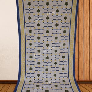 May include: A rectangular area rug featuring a light gray background with a repeating pattern of dark green floral-like shapes and blue horizontal lines. The rug is framed by a yellow Greek key border and a solid blue outer edge with text.