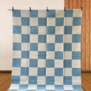 May include: A rectangular rug featuring a repeating checkered pattern of light blue and off-white squares. The textile displays a consistent grid design across its entire surface, with the text FloorAndRugs visible in a subtle watermark style.