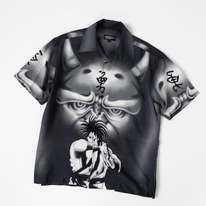 May include: A black and white short-sleeve button-down shirt featuring an airbrushed graphic of a horned demon face and a central character figure. The design includes Japanese kanji characters on the chest and sleeves with a collared neckline.